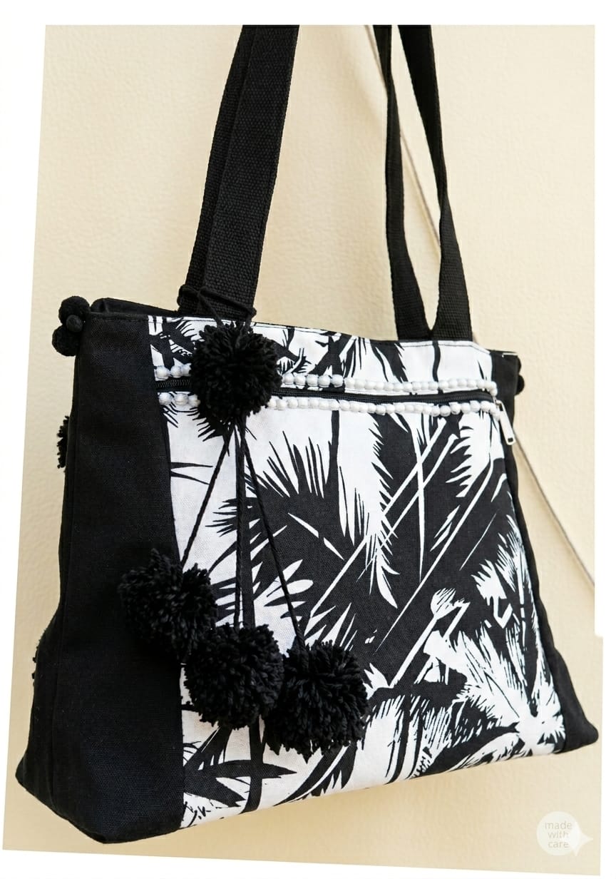 Handcrafted Black & Off-White Khaddar Tote Bag with Tropical Print and Pom-Pom Accents